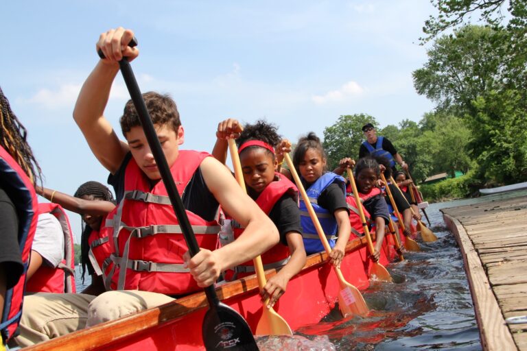 A middle school dragon boating team pushes off from a temporary dock on the Schuylkill River. (Emma Lee/for NewsWorks)