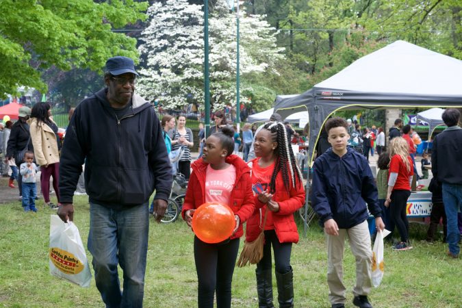 East Mt Airy resident Stephen “Woowoo” Woolson strolls over the grounds at Mt Airy Day, with him second to the right, is his niece Abriah Clark. (Bastiaan Slabbers for WHYY)
