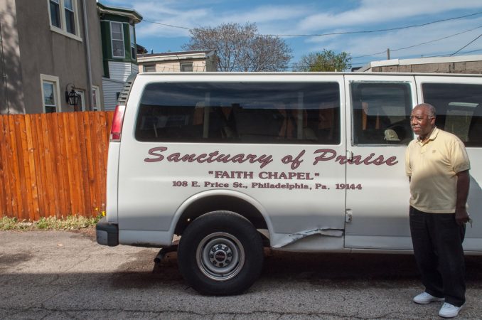 Deacon Harding standing in front of the church van