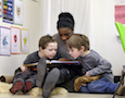 a teacher reads to two children