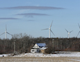 wind turbines behind a farmhouse