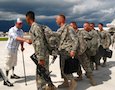 Army servicemen are greeted by a veteran