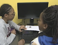 two girls use a computer