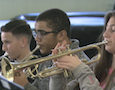a trio of students play trumpets