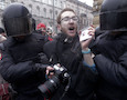 Riot policemen detain a journalist during a protest rally in St.Petersburg, Russia