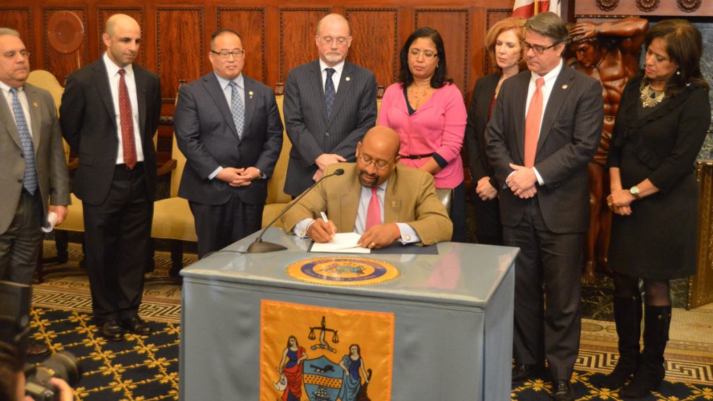12-22-comcast-bill-signing Mayor Michael Nutter signs the new agreement between Philadelphia and Comcast, Inc. (Tom MacDonald/WHYY)