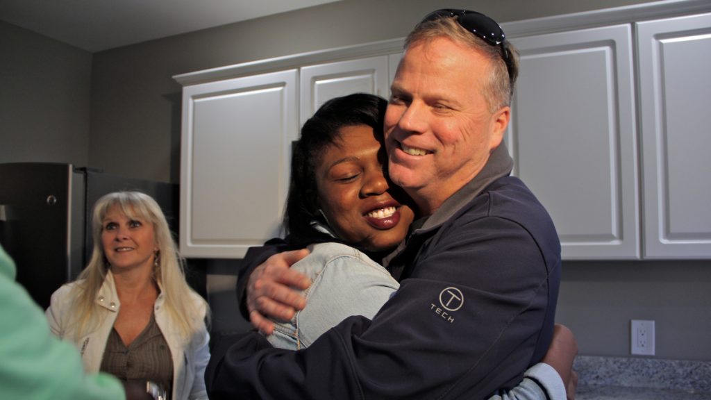 1home donation Army veteran and single mother Janne Dawson hugs Gary Smith, a Mullica Hill contractor who bought and renovated an abandoned home in Camden and gave it to her through Catholic Charities. (Emma Lee/WHYY)