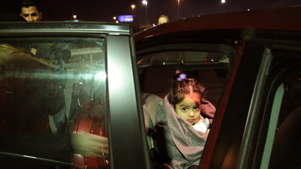1noor Three-year-old Noor Hasan is settled into a car seat in the cell phone lot at Philadelphia airport after her family's flight from Burma. (Emma Lee/WHYY)