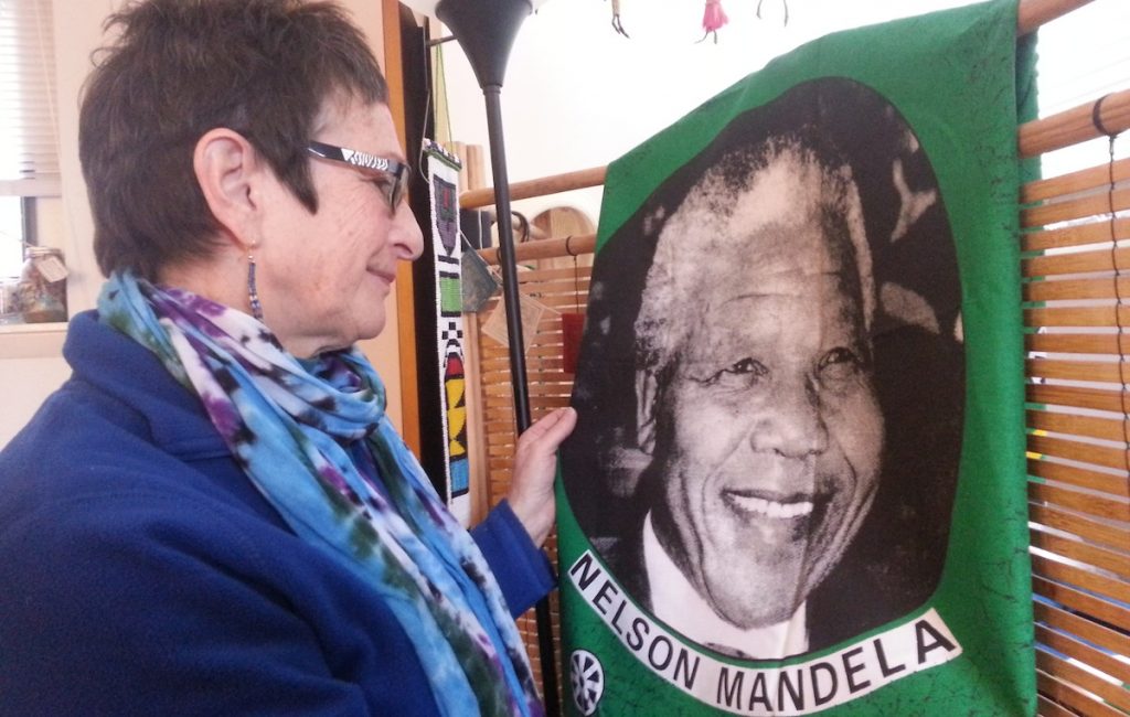  Marilyn Cohen looks fondly at a piece of Nelson Mandela memorabilia from her years in South Africa. (Aaron Moselle/WHYY) 