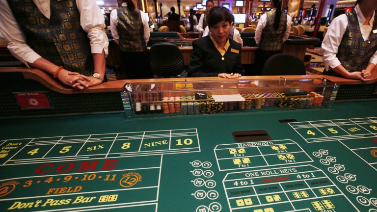  Casino workers stand at gaming tables inside the Sands Cotai Central, in Macau. (AP Photo/Kin Cheung) 