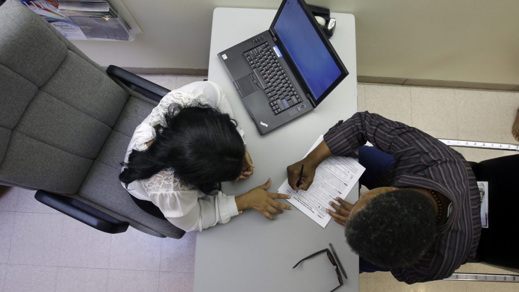 Rachael Richardson, Louis Peters At a health center in Trenton, Rachael Richardson, (left), helps Louis Peters to sign-up for a new health insurance plan (Mel Evans/AP Photo)