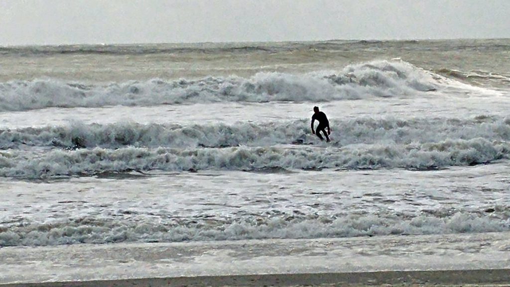 20150904-ocean-city-tom A surfer rides the rough waters off Ocean City