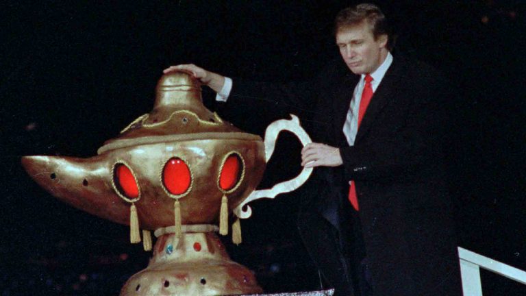 Donald Trump rubs a genie's lamp during grand opening ceremonies for the Trump Taj Mahal Casino Resort in Atlantic City April 6
