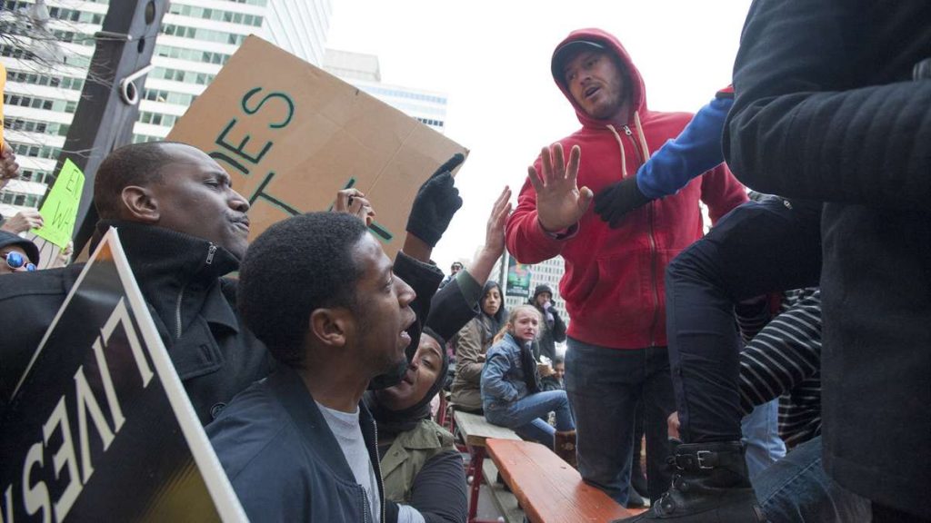 2016_mummers_20160102_1103987425 An unidentified spectator, right intervenes to diffuse a confrontation between Black Lives Matter protesters and several Mummers spectators. (Jonathan Wilson/for NewsWorks)
