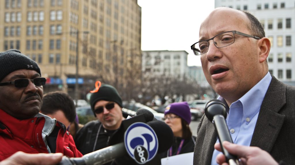 School district spokesperson Fernando Gallard responds to protestors from 32BJ following the injury of one of their workers restarting a boiler in Edmonds Elementary school. (Kimberly Paynter/WHYY)