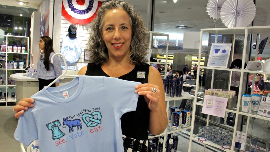 Bucks County artist LisaBeth Weber shows off one of her designs for official Democratic National Convention merchandise. (Emma Lee/WHYY)