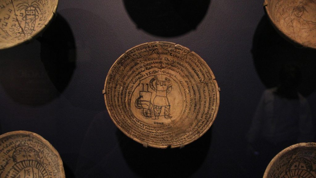 3leadincantation bowls Incantation bowls were decorated with images of bound demons enveloped by spiraling incantations. They were placed upside down at the entrances of Mesopotamian homes for protection. (Emma Lee/WHYY)
