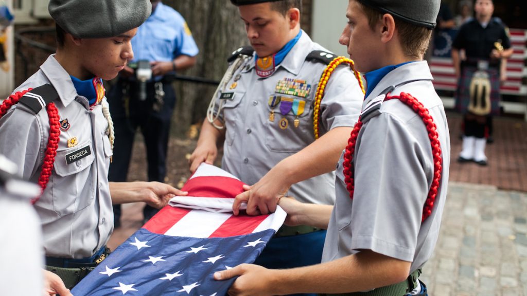 9-11_memorial-14 Members of the Frankford High School ROTC Program fold a flag to honor fallen police and firefighters on September 11, 2016. (Brad Larrison for NewsWorks)