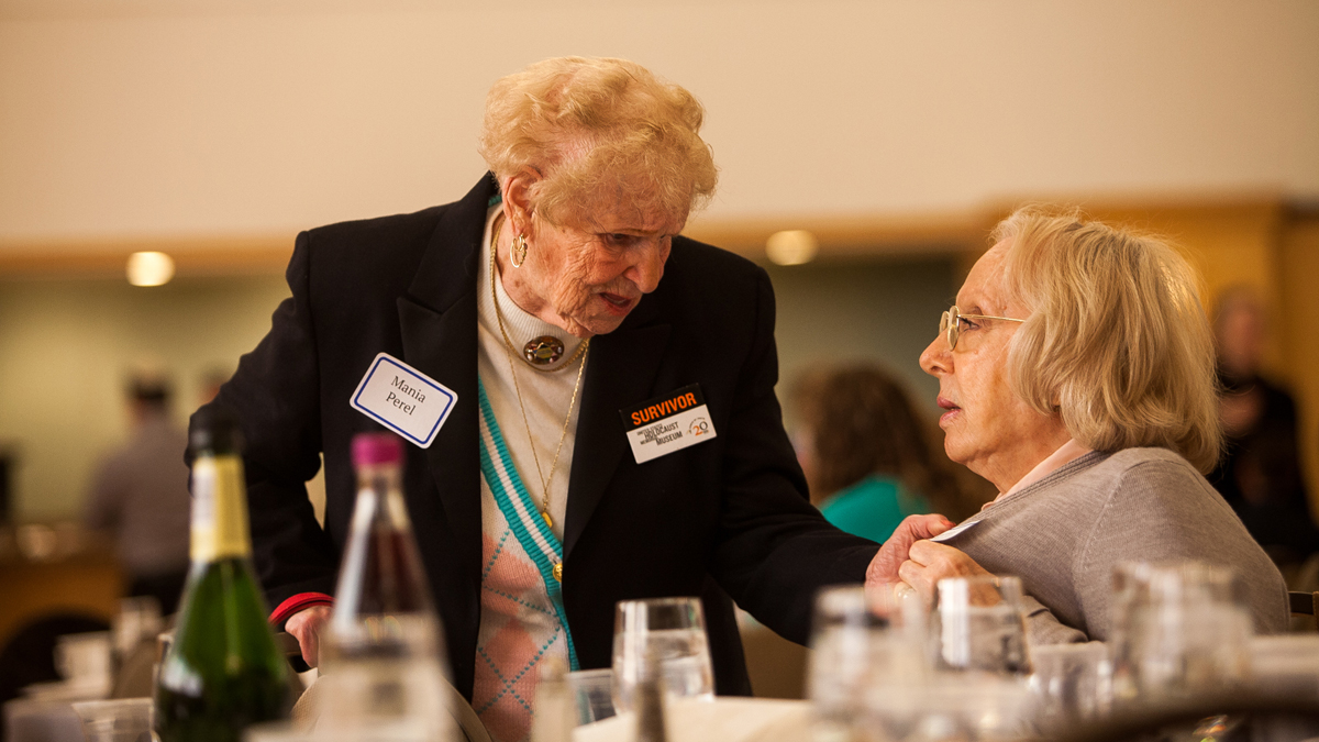 Holocaust survivor Mania Perel, left, speaks with Marta Gherovici who's husband also lived through the Holocaust. (Brad Larrison/for NewsWorks)