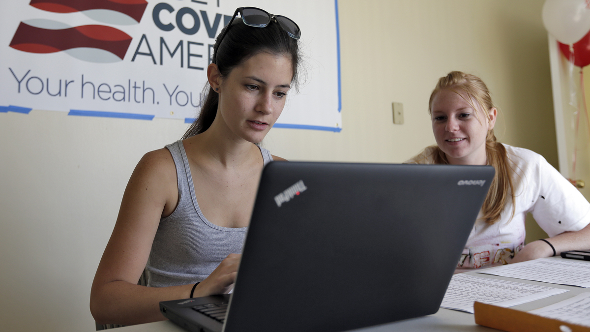  Ashley Hentze, left, of Lakeland, Fla., gets help signing up for the Affordable Care Act from Kristen Nash, a volunteer with Enroll America.  (AP Photo/Chris O'Meara) 