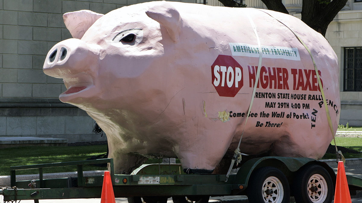  A pig parked next to the New Jersey Statehouse in Trenton expresses the sentiments of taxpayers in 2008 -- which has not changed since then. State officials say merging municipal services could help keep costs down.(AP file photo) 