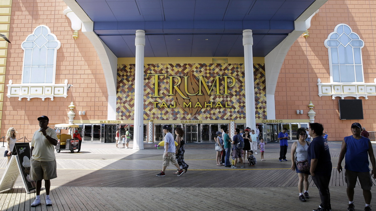  People walk on The Boardwalk near Trump Taj Mahal Casino Resort in Atlantic City in July. Trump Entertainment Resorts has filed for bankruptcy may shut down the casino in November. (AP file photo) 