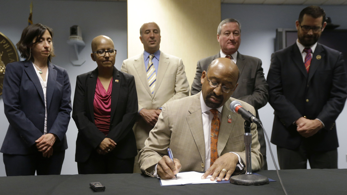  Mayor Michael Nutter signs legislation that broadened equality protections for lesbian, gay, bisexual, and transgender people living and working in the city. Gloria Casarez, second from left, was among those looking on at the 2013 signing. Casarez died Sunday of cancer.(AP file photo) 
