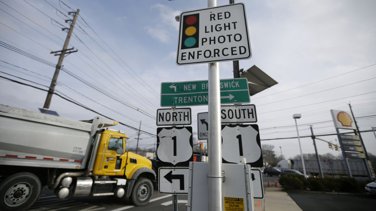  A truck passes a photo enforcement sign that is placed below a red-light camera at the intersection of Route 1 and Franklin Corner Road Tuesday in Lawrence. By midnight, Tuesday, cameras that have recorded hundreds of thousands of red-light violations in two dozen towns are scheduled to go dark as the much-scrutinized pilot program comes to an end after five years filled with controversy. (AP Photo/Mel Evans) 