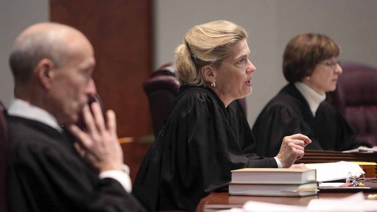 A row of judges are seated at a table.