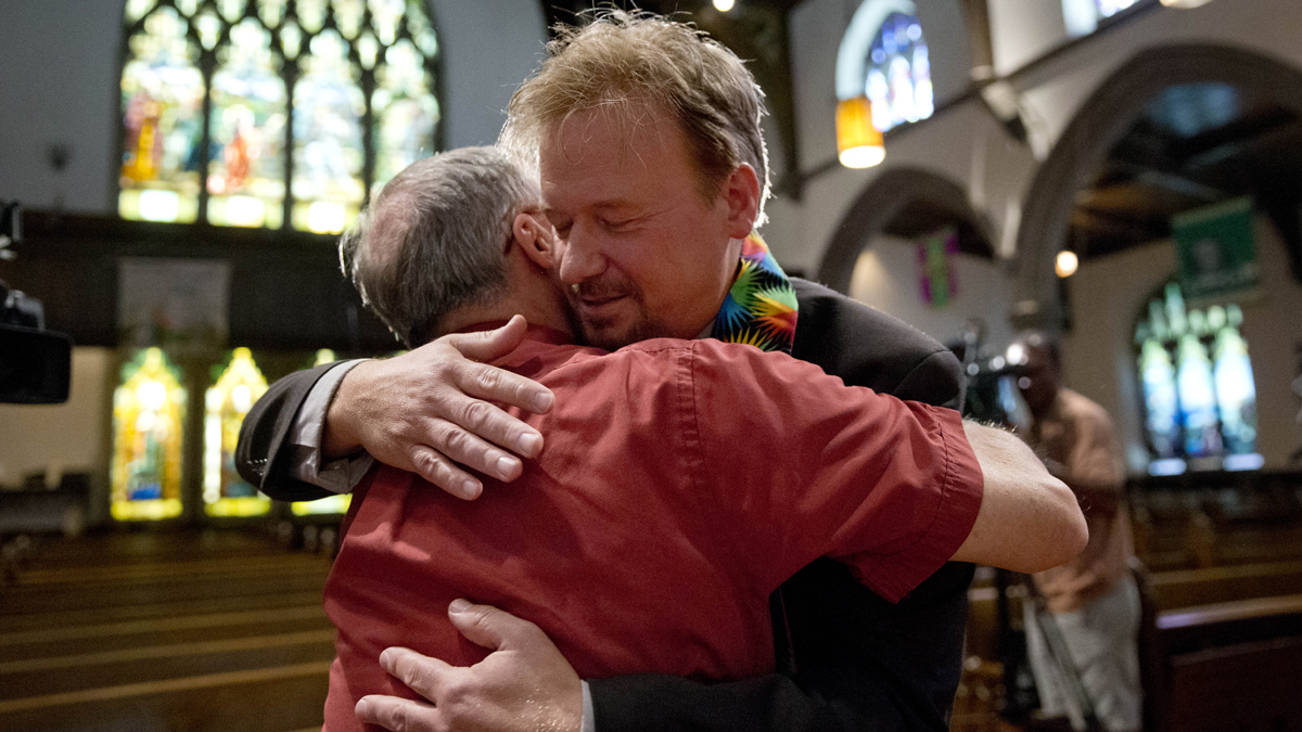  United Methodist pastor Frank Schaefer, right, hugs the Rev. David Wesley Brown Tuesday at First United Methodist Church of Germantown in Philadelphia. Schaefer, who presided over his son's same-sex wedding ceremony and vowed to perform other gay marriages if asked, can return to the pulpit after a United Methodist Church appeals panel  overturned a decision to defrock him. (AP Photo/Matt Rourke) 