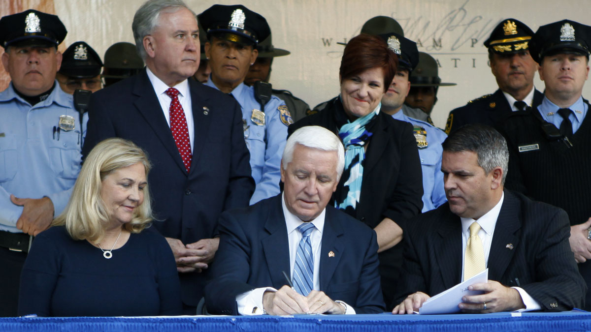  Gov. Tom Corbett, center, signs the law last month as Maureen Faulkner, widow of police Officer Daniel Faulkner, and Pa. state Rep. Mike Vereb look on. Tuesday Oct. 21, 2014 in Philadelphia. Corbett said the measure was intended to curb the 