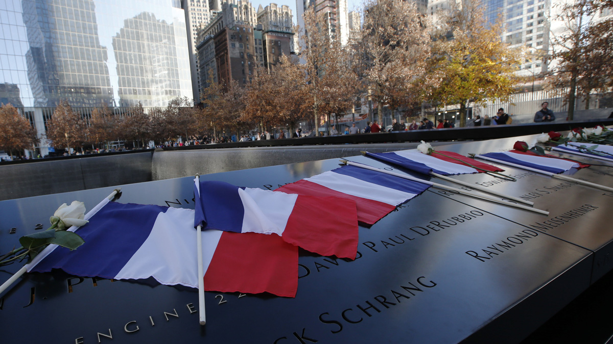 French flags rest on the engraved names at the 9/11 Memorial South Pool rim at the National September 11 Memorial and Museum following a tribute to victims of the  Paris terrorist attacks. (Kathy Willens/AP)
