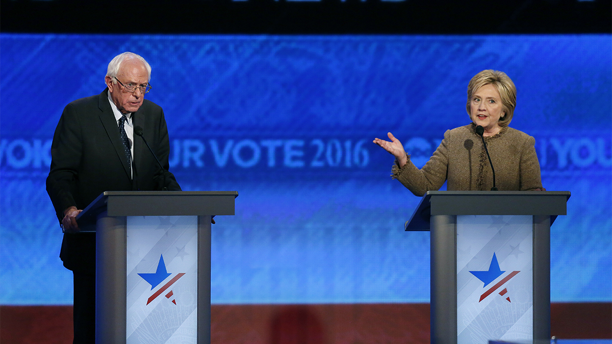  Bernie Sanders, left, listens as Hillary Clinton speaks during a Democratic presidential primary debate Saturday, Dec. 19, 2015, at Saint Anselm College in Manchester, N.H. (AP Photo/Jim Cole) 