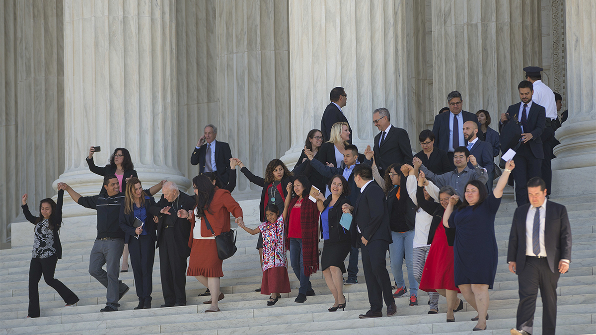 Supporters of  immigration reform hold hands as they leave together after hearing arguments at the Supreme Court in the case U.S. versus Texas Monday in Washington. (AP Photo/Pablo Martinez Monsivais)