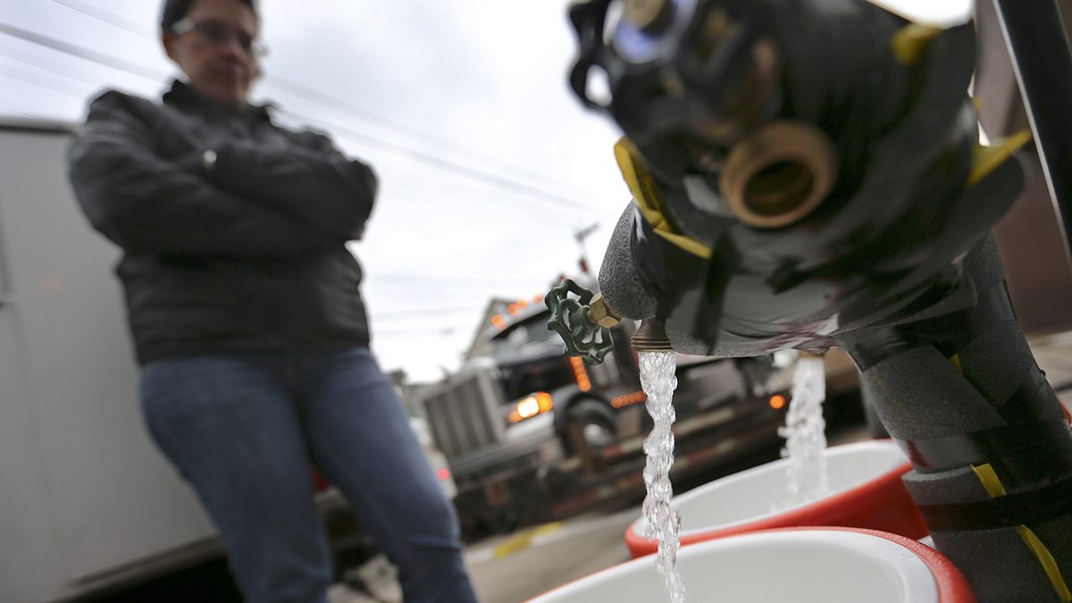 Ronette Cooley fills water containers at a fire station in Pittsburgh's Lawrenceville neighborhood. The City of Pittsburgh set up 15 water stations across the city to provide residents under a flush and boil advisory with potable water. Lower than normal levels of chlorine were found at a city reservoir that supplies water to much of the central and eastern parts of the city. (AP Photo/Keith Srakocic)