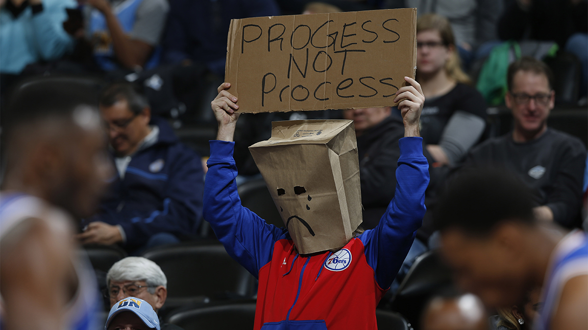 A Philadelphia 76ers fan wears a bag over his head and holds up a placard while watching his team face the Denver Nuggets in the first half of an NBA basketball game Wednesday