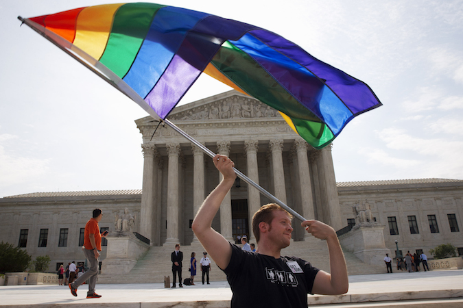  John Becker, 30, of Silver Spring, Md., waves a rainbow flag in support of gay marriage outside of the Supreme Court in Washington. (AP Photo/Jacquelyn Martin) 