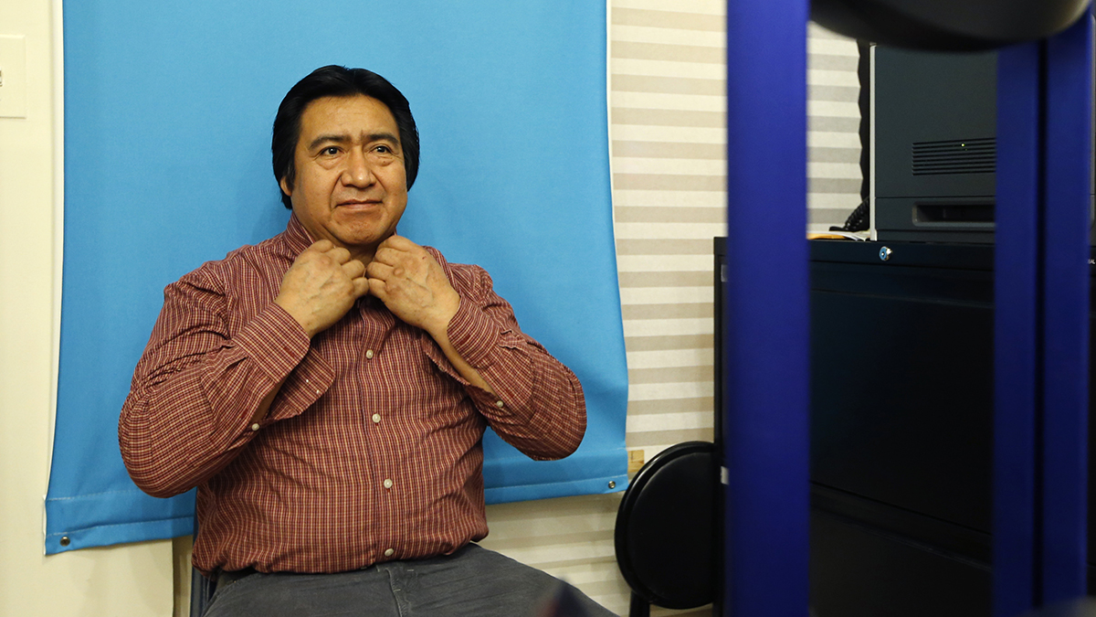  Luis Gordillo, a carpenter from Ecuador, adjusts his shirt collar as he has his picture taken while applying for a New York City municipal ID card. (AP Photo/Kathy Willens) 