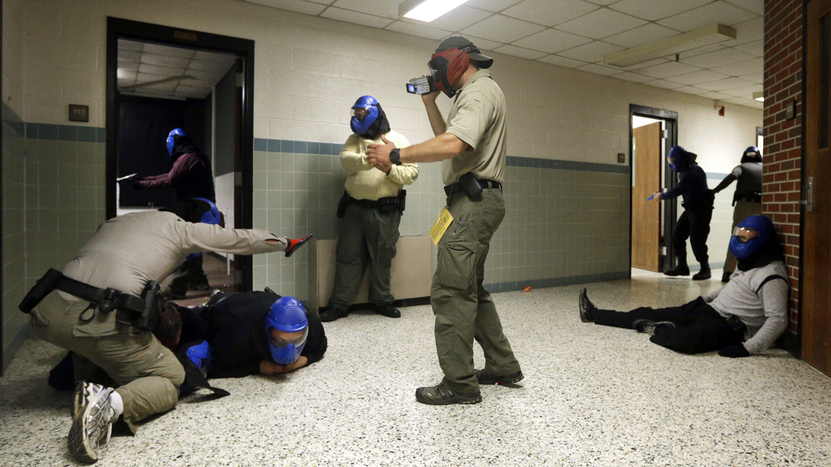  FBI instructor Mike Sotka, center, films  police officers in 2013 as they participate in an active shooter drill in a college classroom building in Salisbury, Maryland, as part of an FBI program that teaches local law enforcement best practices for responding to mass shootings. (Patrick Semansky/AP Photo) 