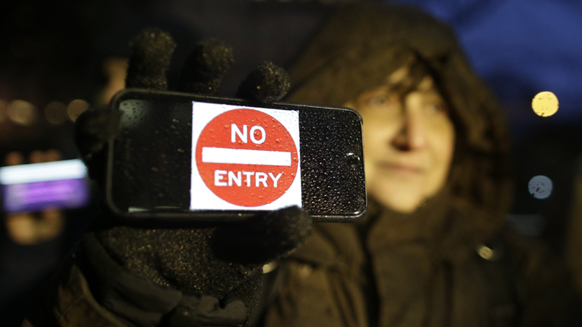 A demonstrator stands outside the Apple store on Fifth Avenue