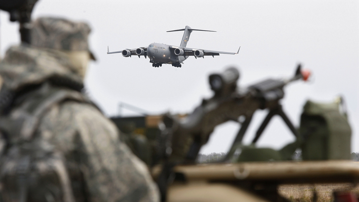 An Army guard looks on as an Air Force C-17 cargo plane lands at Joint Base McGuire Dix Lakehurst in New Jersey. (Mel Evans/AP file photo)