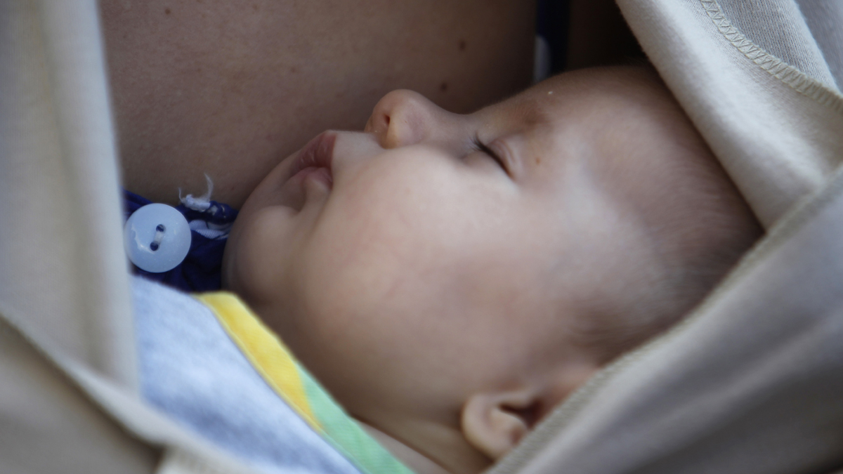  A baby sleeps in the arms of his mother after a mass breastfeeding in celebration (Nikolas Giakoumidis/AP Photo) 