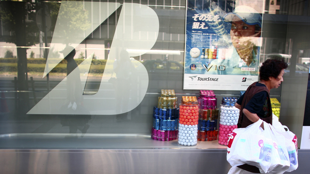  A shopper strolls by Bridgestone's head office in Tokyo (Junji Kurokawa/AP Photo) 