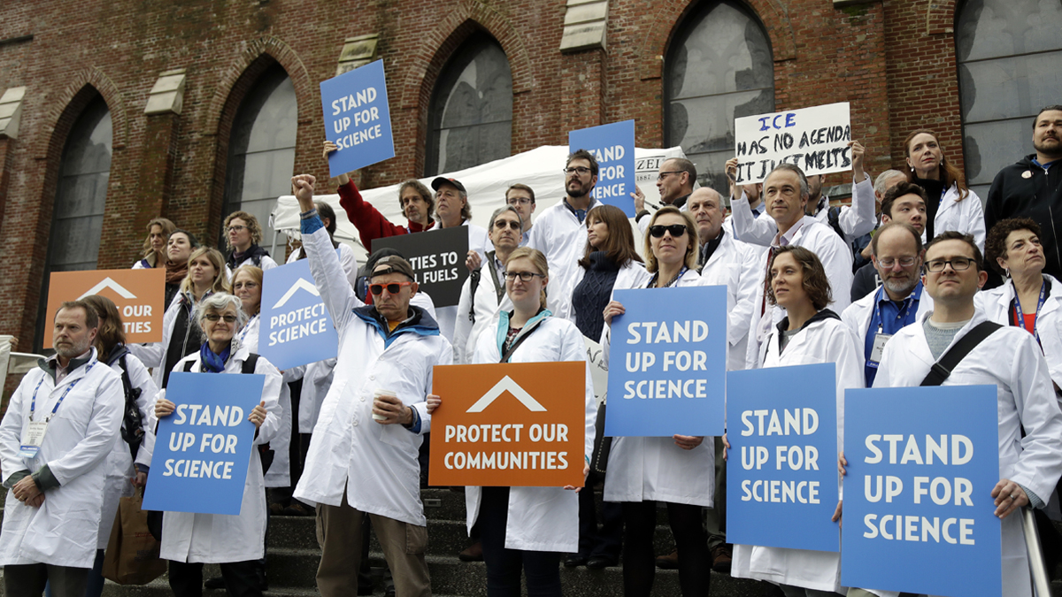 Scientists hold signs during a rally in conjunction with the American Geophysical Union's fall meeting Tuesday