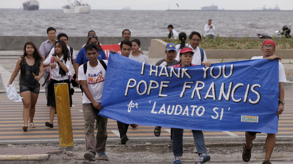  Environmental activists carry a banner as they march toward a Roman Catholic church to coincide with Pope Francis' encyclical on climate change Thursday in Manila, Philippines. In a high-level, 190-page document released Thursday, Pope Francis  describes ongoing human damage to nature as 'one small sign of the ethical, cultural and spiritual crisis of modernity.' (Bullit Marquez/AP Photo) 