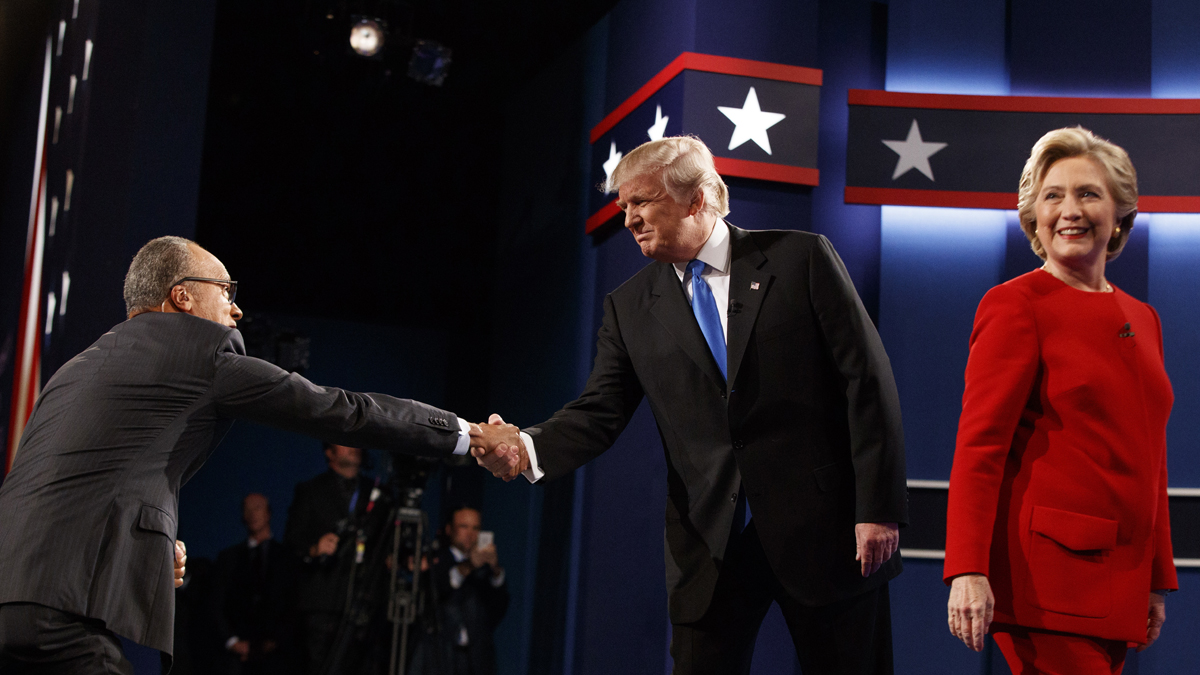Republican presidential candidate Donald Trump (center) shakes hands with moderator Lester Holt (left) as Democratic presidential candidate Hillary Clinton walks to her lectern during the first presidential debate at Hofstra University