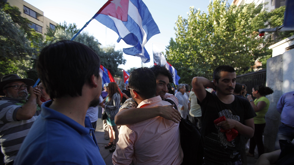  People embrace while celebrating the restoration of diplomatic relations between Cuba and the United States, outside of the Cuban Embassy in Santiago, Chile, Wednesday Dec. 17, 2014. After a half-century of Cold War acrimony, the United States and Cuba abruptly moved on Wednesday to restore diplomatic relations between the two nations. U.S. President Barack Obama spoke as Cuban President Raul Castro was addressing his nation in Havana, where church bells rang and school teachers paused lessons to mark the news. (Luis Hidalgo/AP Photo) 