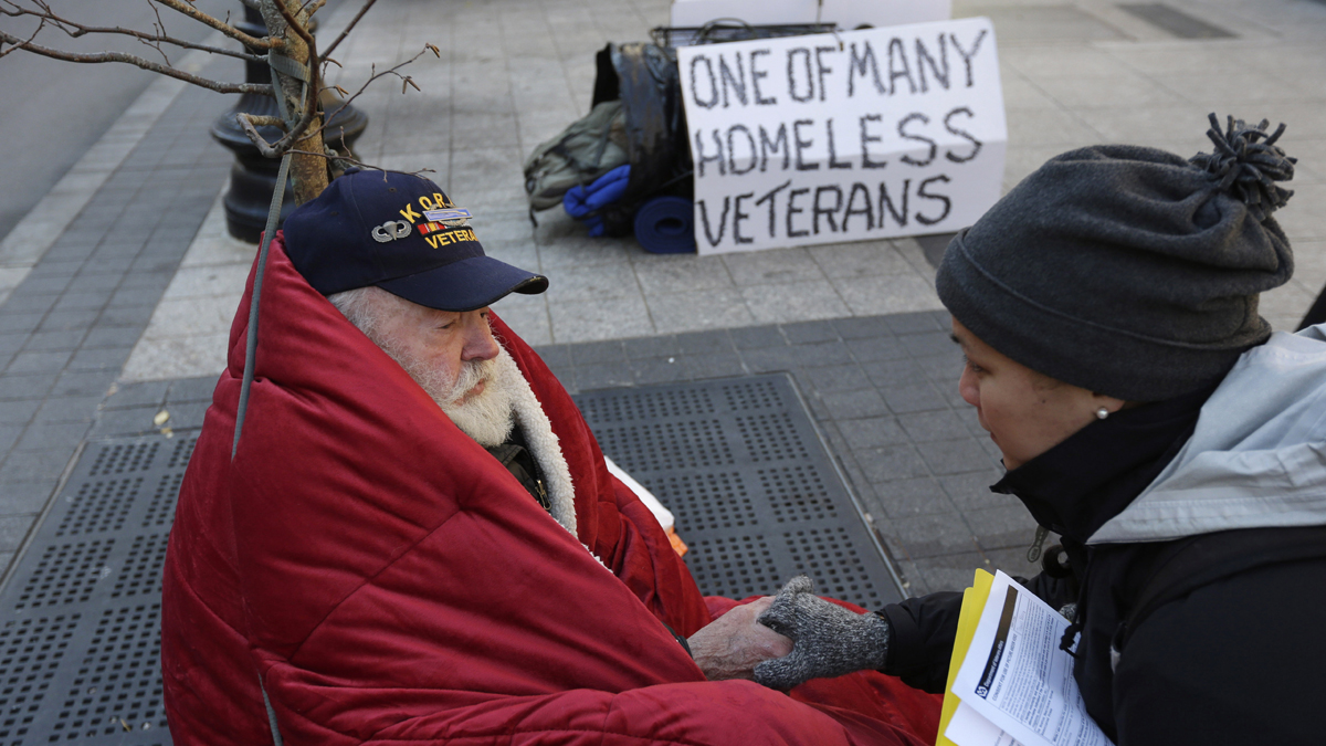  In this November 2013 photo, homeless Korean War veteran Thomas Moore, 79, left, speaks with Boston Health Care for the Homeless street team outreach coordinator Romeena Lee on a sidewalk in Boston. Moore said he accidentally killed his best friend with a phosphorous grenade during one firefight and spent months afterward at Walter Reed Army Medical Center in Washington. (Steven Senne/AP Photo) 