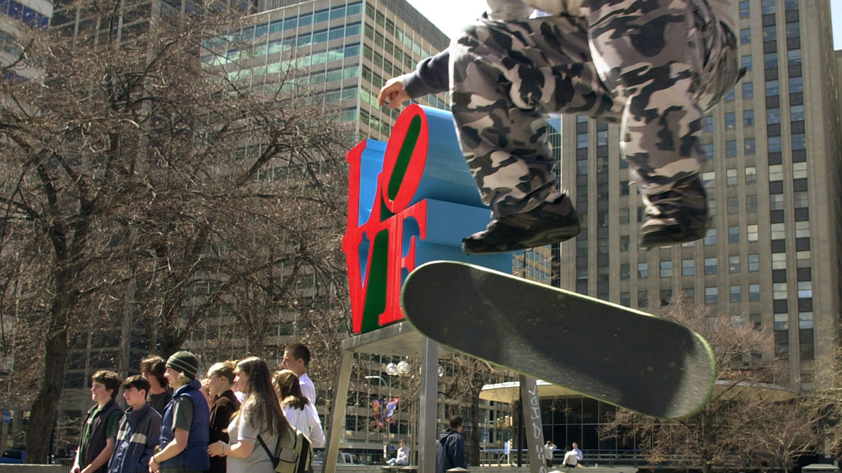  Mike Cole, 14, of Jenkintown, Pa., performs a kick-flip over a trash can in JFK Plaza, or 'Love Park' as it's known to skateboarders, while tourists pose for a photograph in Philadelphia.  (Douglas Bovitt/AP Photo, file) 