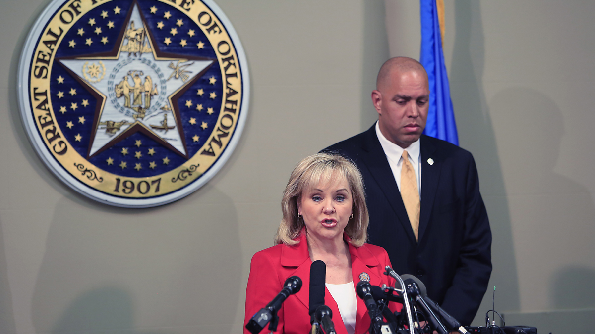  In this April 30, 2014 file photo, Oklahoma Gov. Mary Fallin, front, issues a statement to the media on the Execution of Clayton Lockett as Oklahoma Secretary of Safety and Security Michael C. Thompson, back, listens from the Oklahoma State Capitol in Oklahoma City. The botched execution of Lockett, and the gruesome details of him writhing and moaning before dying of a heart attack, has outraged death penalty opponents, raised the potential of more court challenges and received international attention. (Alonzo Adams/AP Photo, file) 